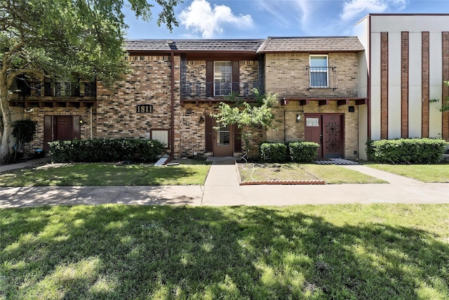 1811 E Grauwyler Rd Unit 138, Irving, TX 75061 - view of front facade featuring brick siding and a front lawn