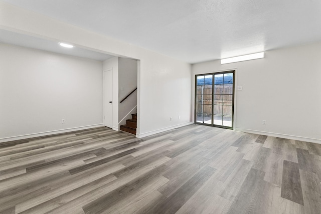 1811 E Grauwyler Rd Unit 138, Irving, TX 75061 - empty room with stairway, wood finished floors, and baseboards