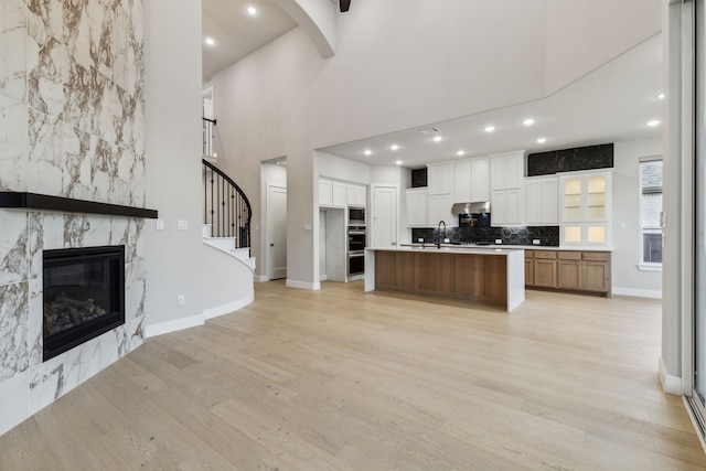 2921 Citation Rd, Celina, TX 75009 - kitchen with appliances with stainless steel finishes, light wood finished floors, under cabinet range hood, baseboards, and white cabinets