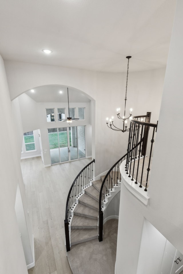 2921 Citation Rd, Celina, TX 75009 - stairway featuring arched walkways, wood finished floors, baseboards, ceiling fan, and a chandelier