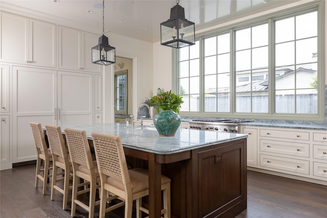 5610 Lobello, Dallas, TX 75229 - kitchen featuring light stone countertops, white cabinets, dark wood-type flooring, and pendant lighting