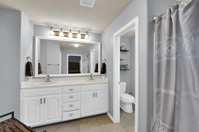 5061 Britton Ridge Ln, Fort Worth, TX 76179 - bathroom featuring tile patterned floors, double vanity, toilet, and a textured ceiling