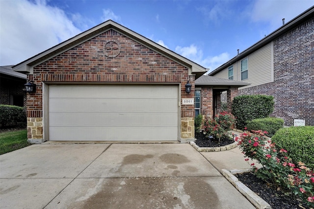 5061 Britton Ridge Ln, Fort Worth, TX 76179 - ranch-style home with concrete driveway, brick siding, a garage, and stone siding