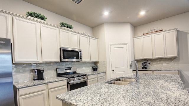 7436 Palisades Dr, Rowlett, TX 75088 - kitchen featuring appliances with stainless steel finishes, a sink, decorative backsplash, light stone counters, and recessed lighting
