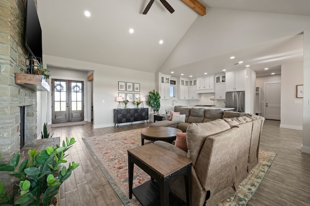 1196 Smith Rd, Ponder, TX 76259 - living room featuring high vaulted ceiling, beam ceiling, baseboards, ceiling fan, and a stone fireplace