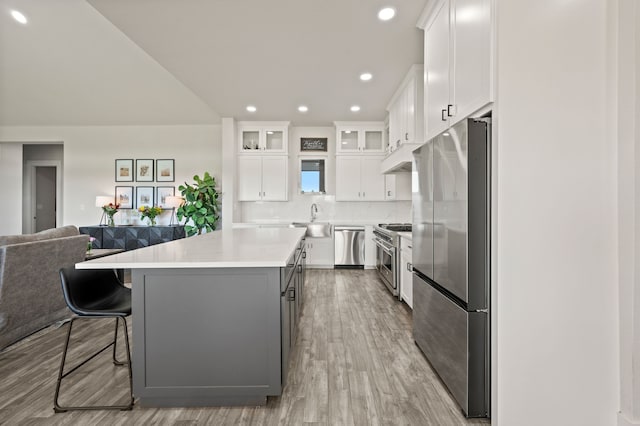 1196 Smith Rd, Ponder, TX 76259 - kitchen with appliances with stainless steel finishes, a sink, open floor plan, a center island, and light wood-style floors