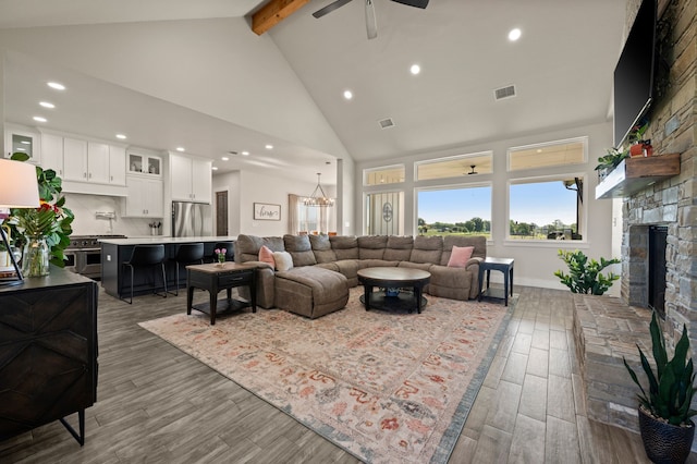 1196 Smith Rd, Ponder, TX 76259 - living area with beam ceiling, high vaulted ceiling, a ceiling fan, a stone fireplace, and wood finished floors