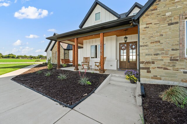 1196 Smith Rd, Ponder, TX 76259 - property entrance featuring board and batten siding, a porch, stone siding, and french doors