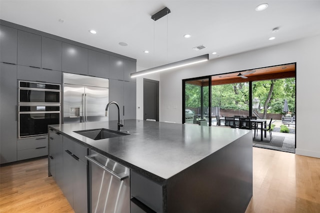 10026 Mccree Rd, Dallas, TX 75238 - kitchen featuring a sink, modern cabinets, stainless steel appliances, dark countertops, and light wood-style flooring