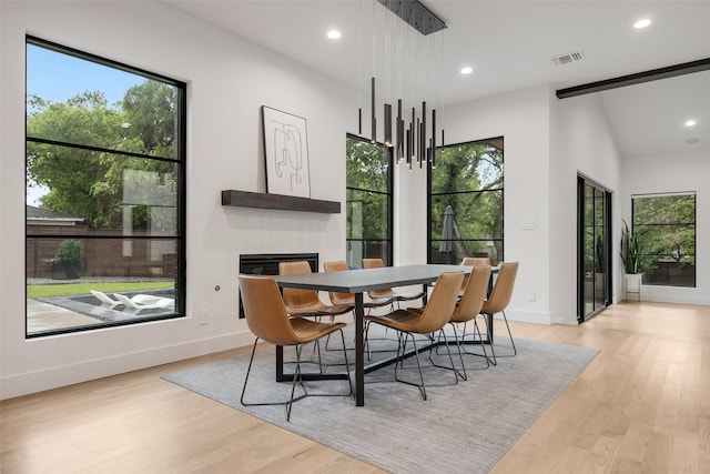 10026 Mccree Rd, Dallas, TX 75238 - dining area featuring light wood finished floors, recessed lighting, baseboards, and a glass covered fireplace