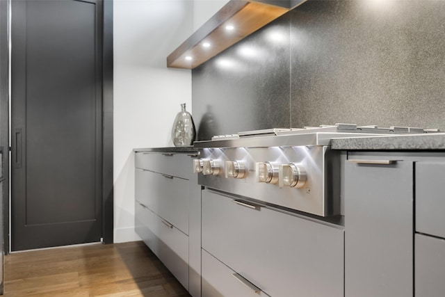 10026 Mccree Rd, Dallas, TX 75238 - detailed view of recessed lighting, wood finished floors, modern cabinets, and stainless steel gas cooktop