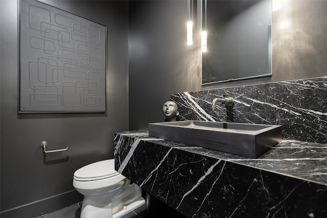 10026 Mccree Rd, Dallas, TX 75238 - bathroom featuring a sink, toilet, and decorative backsplash
