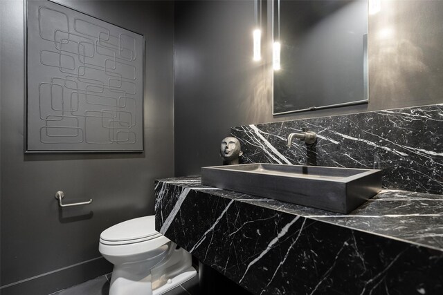 10026 Mccree Rd, Dallas, TX 75238 - bathroom with toilet, a sink, and backsplash