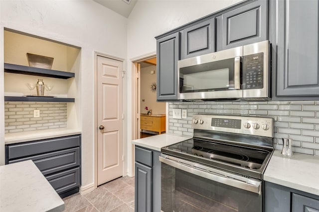 49 Sonora Dr, Trophy Club, TX 76262 - kitchen with stainless steel appliances, gray cabinetry, backsplash, light tile patterned floors, and open shelves