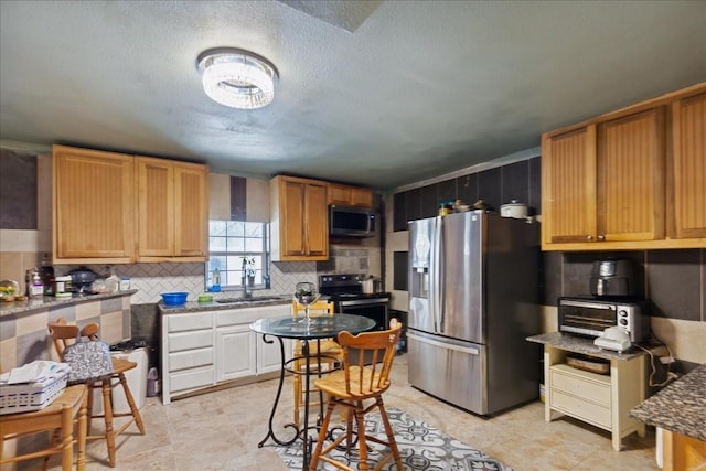 1474 Vz County Road 3810, Wills Point, TX 75169 - kitchen with appliances with stainless steel finishes, a sink, backsplash, and a textured ceiling