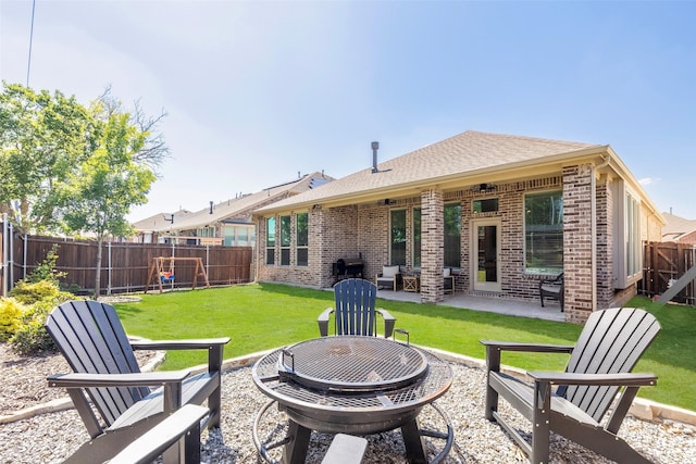 1106 Sassafras Dr, Princeton, TX 75407 - back of house featuring a fire pit, brick siding, a patio, and roof with shingles