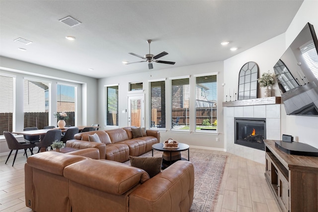 1106 Sassafras Dr, Princeton, TX 75407 - living area featuring light wood-style flooring, plenty of natural light, a tiled fireplace, a ceiling fan, and recessed lighting