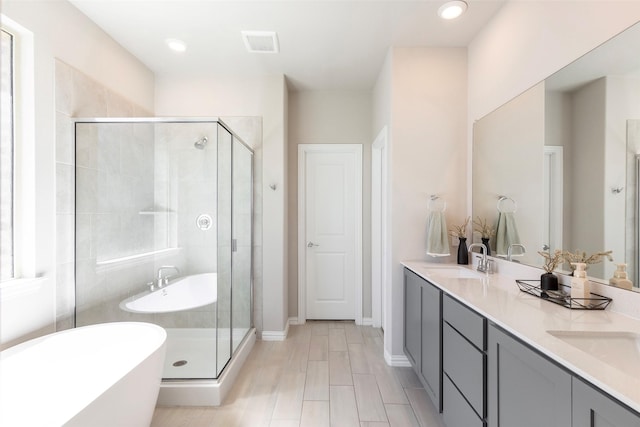 1106 Sassafras Dr, Princeton, TX 75407 - bathroom featuring a shower stall, a freestanding bath, double vanity, baseboards, and recessed lighting