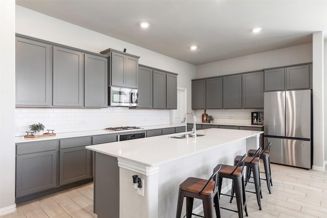 1106 Sassafras Dr, Princeton, TX 75407 - kitchen featuring appliances with stainless steel finishes, a sink, a kitchen breakfast bar, a kitchen island with sink, and tasteful backsplash