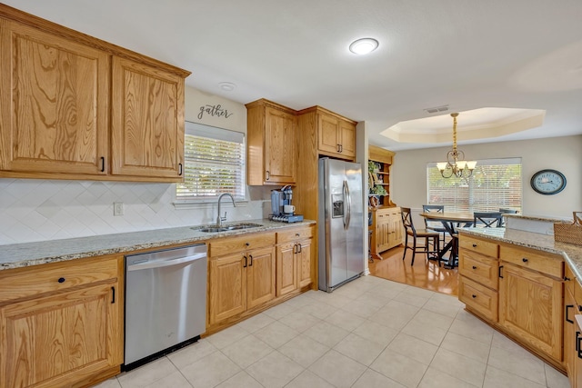 1521 Rice Rd Unit A101, Tyler, TX 75703 - kitchen featuring appliances with stainless steel finishes, a sink, a tray ceiling, backsplash, and a chandelier