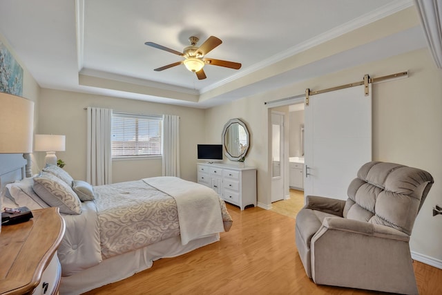 1521 Rice Rd Unit A101, Tyler, TX 75703 - bedroom with a barn door, a tray ceiling, light wood-type flooring, ceiling fan, and crown molding