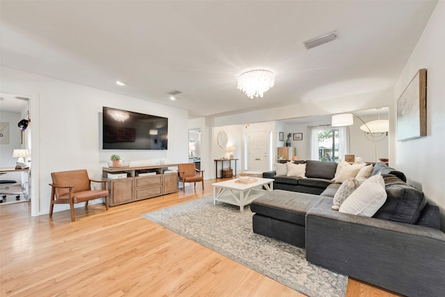 living area featuring a chandelier and light wood-style flooring