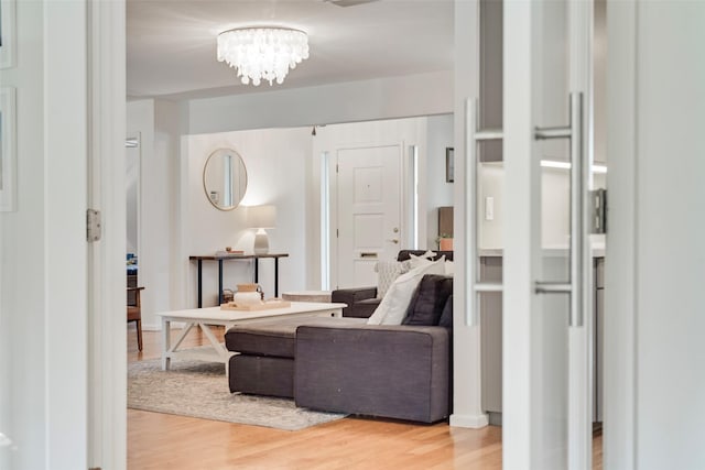 living room with light wood-type flooring and a chandelier