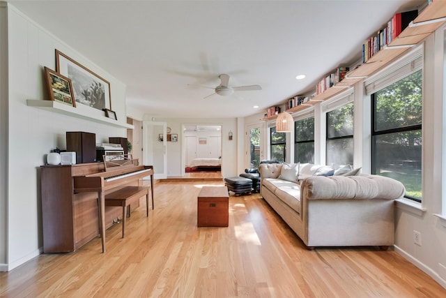living room featuring light wood finished floors, a ceiling fan, baseboards, and recessed lighting