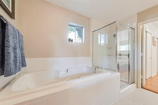 full bathroom with a shower stall, a whirlpool tub, and tile patterned floors