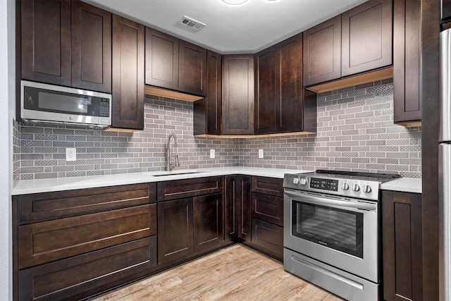 919 Old Justin Rd, Argyle, TX 76226 - kitchen featuring stainless steel appliances, a sink, light countertops, and dark brown cabinets