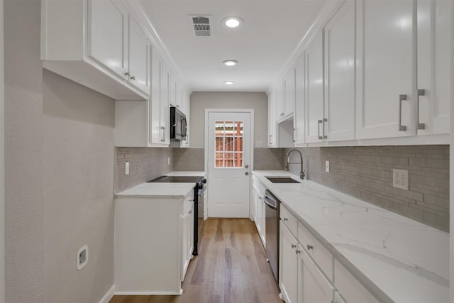 13788 Brookgreen Cir, Dallas, TX 75240 - kitchen featuring black appliances, a sink, white cabinets, backsplash, and recessed lighting