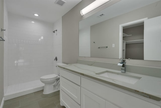 13788 Brookgreen Cir, Dallas, TX 75240 - bathroom with a tile shower, toilet, vanity, tile patterned floors, and recessed lighting