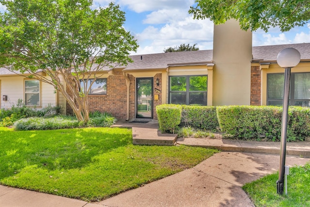 13788 Brookgreen Cir, Dallas, TX 75240 - view of front of house with a front lawn, brick siding, a chimney, and a shingled roof