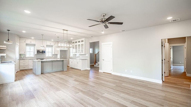 2048 Salina Cir, Granbury, TX 76048 - kitchen with stainless steel microwave, a ceiling fan, white cabinetry, a center island, and recessed lighting