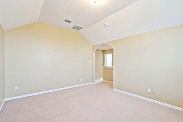 2929 Aurora Mist Dr, Little Elm, TX 75068 - empty room featuring lofted ceiling, arched walkways, light colored carpet, and baseboards
