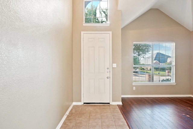 2929 Aurora Mist Dr, Little Elm, TX 75068 - entryway featuring healthy amount of natural light, wood finished floors, a textured wall, lofted ceiling, and baseboards