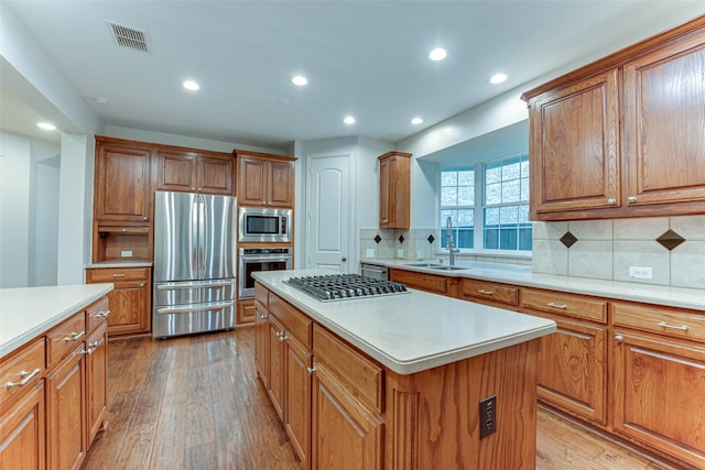 2621 Elmbrook Dr, Carrollton, TX 75010 - kitchen featuring stainless steel appliances, a sink, light wood-style flooring, light countertops, and brown cabinets