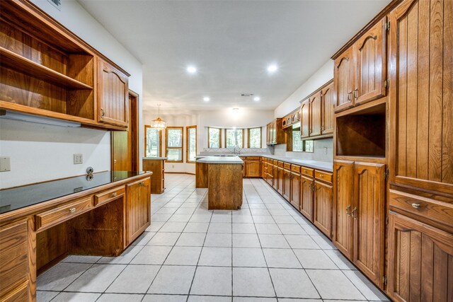 348 Indian Trl, Decatur, TX 76234 - kitchen featuring open shelves, light tile patterned floors, brown cabinetry, recessed lighting, and a kitchen island