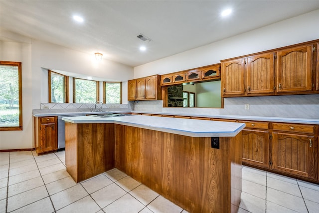 348 Indian Trl, Decatur, TX 76234 - kitchen with light countertops, brown cabinetry, a center island, decorative backsplash, and recessed lighting