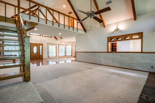 348 Indian Trl, Decatur, TX 76234 - unfurnished living room with high vaulted ceiling, ceiling fan, carpet floors, beam ceiling, and stairs