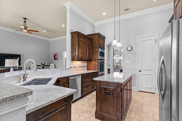 kitchen with stainless steel appliances, a sink, ceiling fan, ornamental molding, and tasteful backsplash