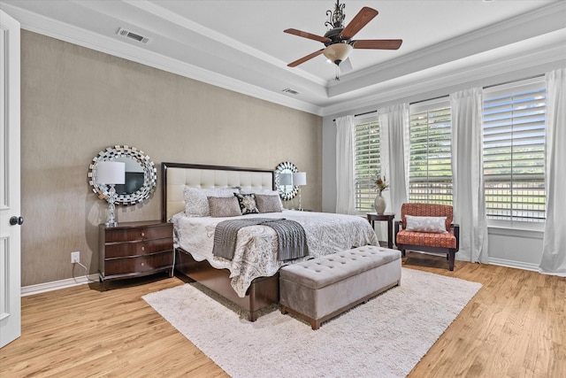 bedroom with wood finished floors, multiple windows, crown molding, and baseboards