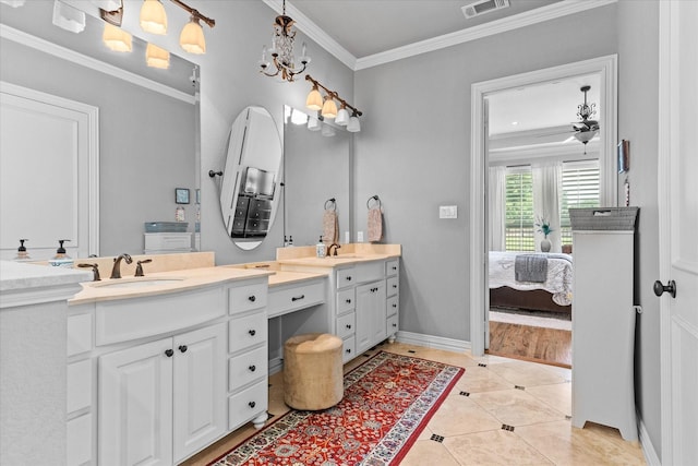 ensuite bathroom with ornamental molding, two vanities, tile patterned flooring, and baseboards