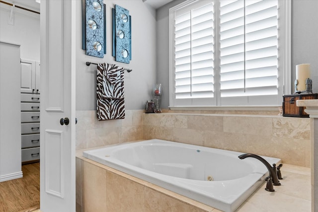 bathroom featuring plenty of natural light, a jetted tub, and wood finished floors