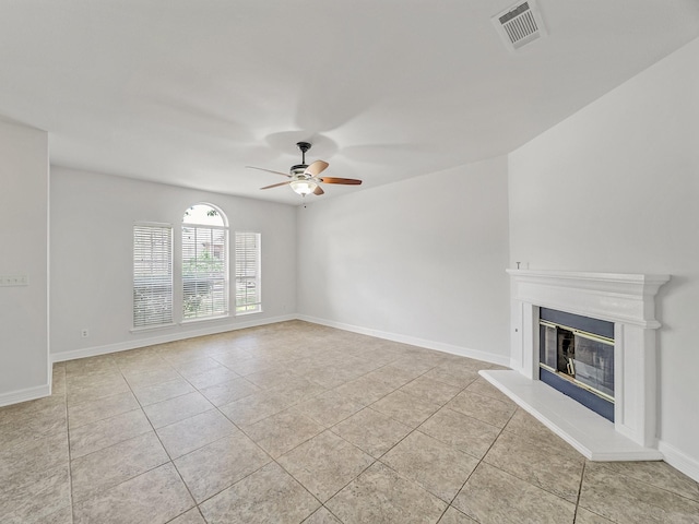 2500 Westheimer Rd, Denton, TX 76210 - unfurnished living room featuring light tile patterned floors, ceiling fan, a glass covered fireplace, and baseboards