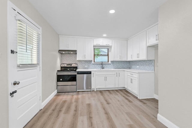501 S Eddy Ave, Denison, TX 75020 - kitchen featuring stainless steel appliances, under cabinet range hood, light wood finished floors, backsplash, and white cabinets