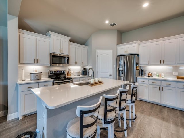 11724 Pistachio Trl, Fort Worth, TX 76108 - kitchen featuring appliances with stainless steel finishes, a sink, wood finished floors, light countertops, and a kitchen island with sink