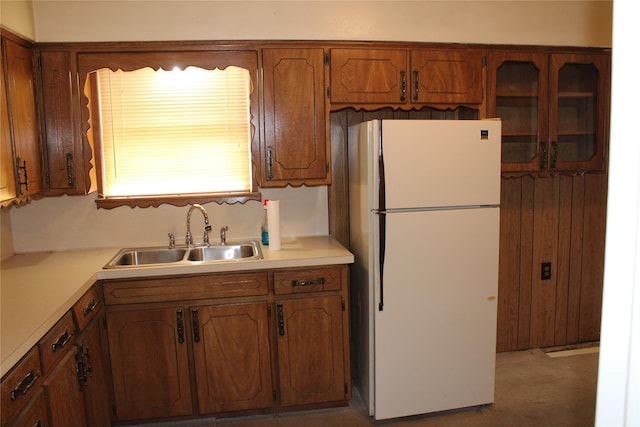 114 Wilmington Ave, Waxahachie, TX 75165 - kitchen featuring freestanding refrigerator, a sink, brown cabinetry, and light countertops