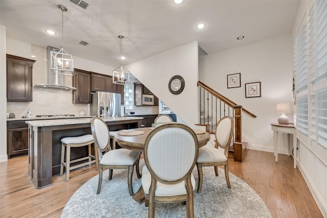 7320 San Saba Dr, Mckinney, TX 75070 - dining area featuring light wood-style floors, recessed lighting, stairway, and a chandelier