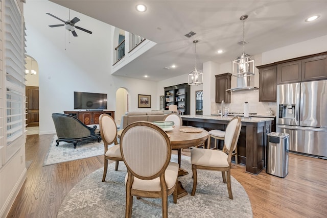 7320 San Saba Dr, Mckinney, TX 75070 - dining room featuring a ceiling fan, light wood-style flooring, recessed lighting, and arched walkways